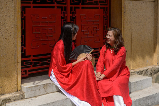 Portrait of Vietnamese mother and daughter in red Ao Dai Dress visit the pagoda on Tet holiday , Lunar new year