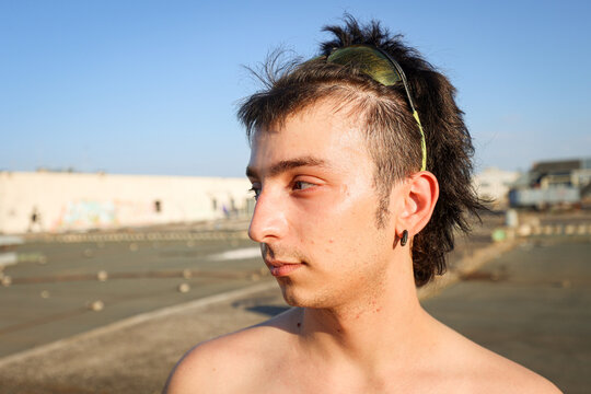 Profile view portrait of young non-binary Gen Z person with mullet