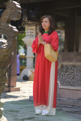 Vietnamese Woman in red ao dai dress on Tet Holiday