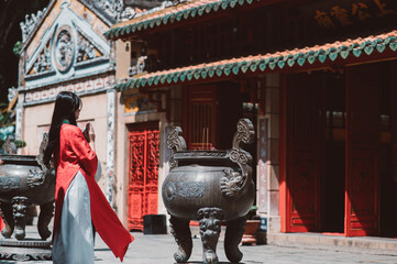 Portrait of teenager girl in Vietnamese Traditional Dress, Ao Dai in the temple 