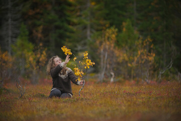 Meditative portrait of a caucasian woman sitting next to a small tree