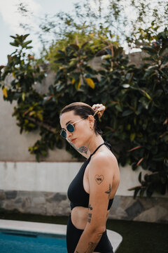 Portrait of woman in swimsuit combing her hair in the garden