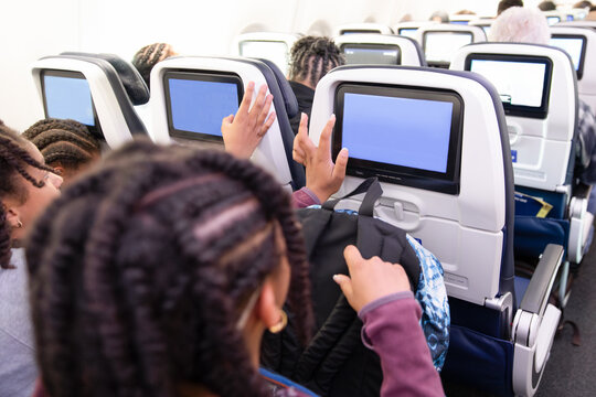 Children selecting movies while on a flight 