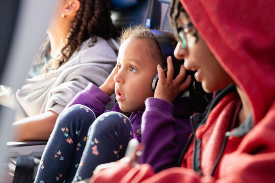 Child on an airline flight adjusting her headphones