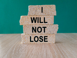 I will not lose symbol. Brick blocks with text I will not lose. Beautiful green background, wooden...
