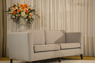 Sofa with Bouquets of colorful flower to decorated in the vase  with curtain background in the living room.
