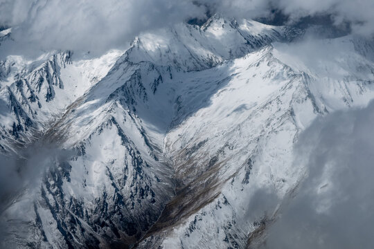 Close up aerial view of mountain ranges looking through the clouds