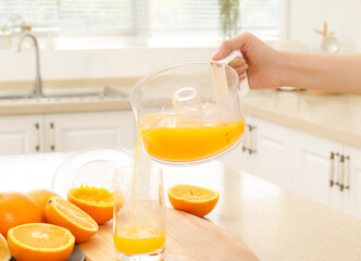 Pour freshly squeezed orange juice from the juicer