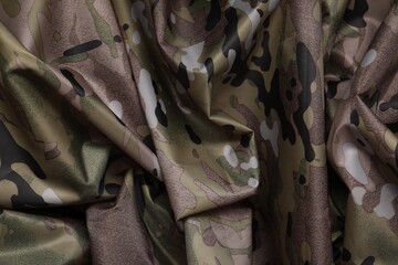 Texture of crumpled camouflage fabric as background, top view