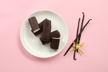 Glazed curd cheese bars, vanilla pods and flower on pink background, top view