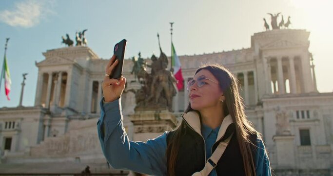 A girl tourist walking through the streets of Rome takes a photo for memory. memorable moments lifestyle travel. High quality 4k footage