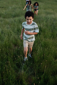 Boy runing through grass.