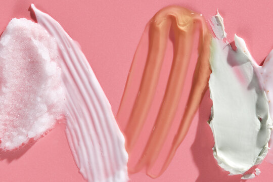 cosmetic smears of creamy texture on a pink background