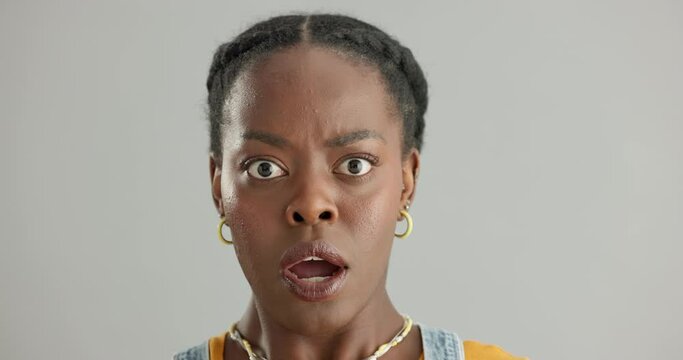 Face, surprise and black woman with omg, announcement and fake news on a grey studio background. Portrait, African person and model with reaction to a secret and gossip with emoji, wtf and shocked
