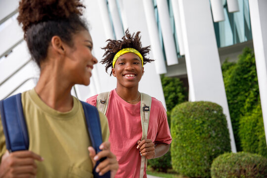Happy high school friends walking on campus