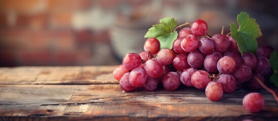 A bunch of grapes sits atop a weathered wooden table, showcasing a rustic charm that evokes a sense of simplicity and natural beauty.