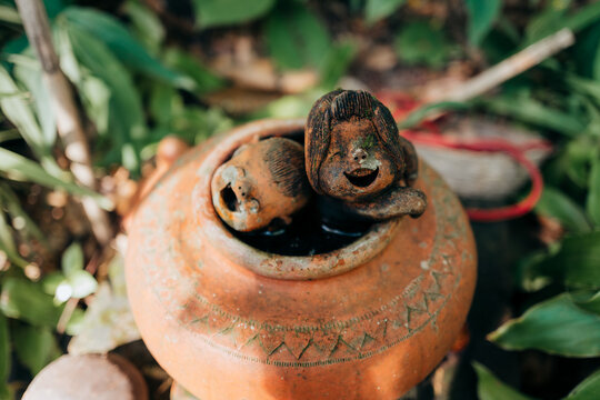 A water jar with two laughing figures in a temple garden in Thailand