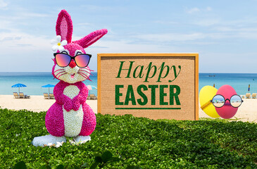 Pink Easter bunny and Easter egg with cardboard sign on tropical beach, Happy Easter card...