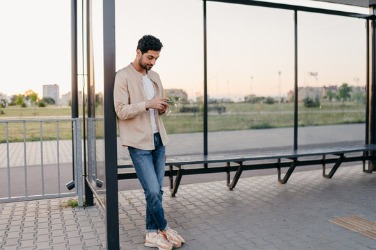 A man uses a mobile phone at a bus station