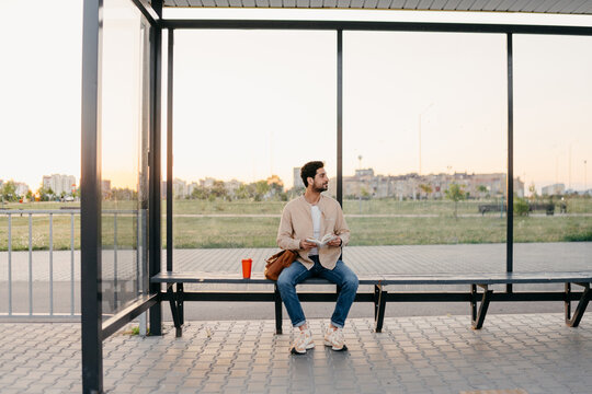 A man reads a book at a bus station