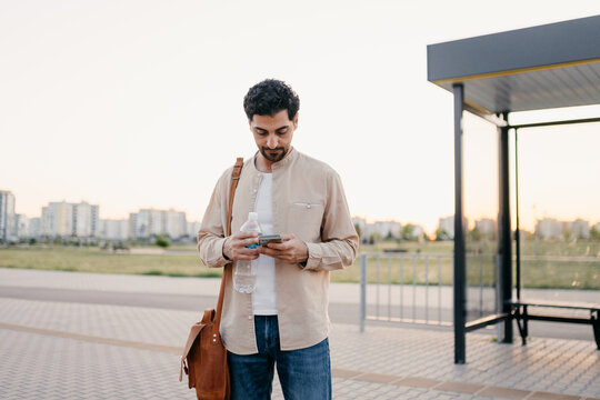 A man uses a mobile phone at a bus station