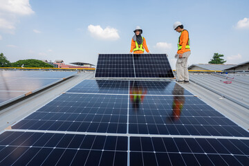 Men technicians carrying photovoltaic solar moduls on roof of factory on the morning. Installing a Solar Cell on a Roof. Solar panels on roof. Workers installing solar cell power plant eco technology.