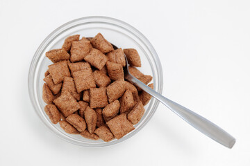 Sweet crispy corn pads in glass bowl on white with spoon