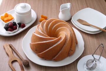 A very delicious and tempting cake served with powdered sugar and fruit