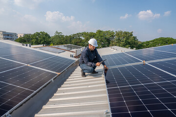 Service Engineer use tablet working inspection installation solar cell on the roof. Technician maintenance solar cells on roof factory. Technology solar energy renewable.