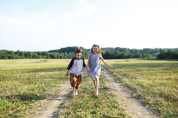 Children walk in the summer in nature. Child on a sunny spring morning in the park. Traveling with children. - 751228177