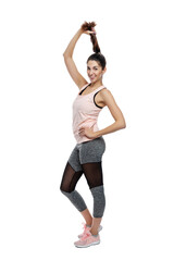 Slender smiling woman in sportswear. A beautiful brunette holds her braid in black leggings and a pink top. Activity, energy and sport. Isolated on a white background. Full height. Vertical.