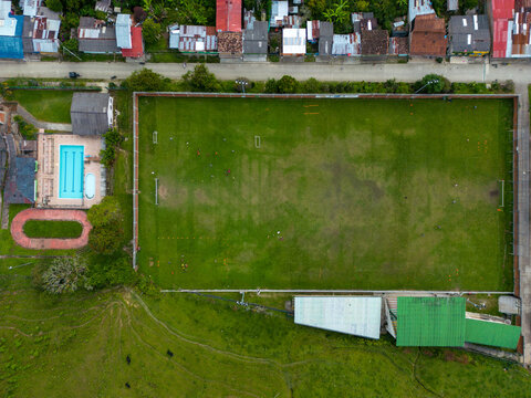 Drone view of municipal township with green field in daylight