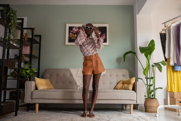 Black fashion influencer putting on sunglasses