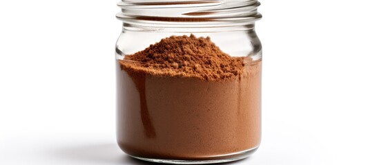 A glass jar filled with brown powder, most likely instant coffee, is placed on top of a clean white...