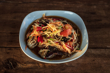 Green papaya salad in a plate on a table.