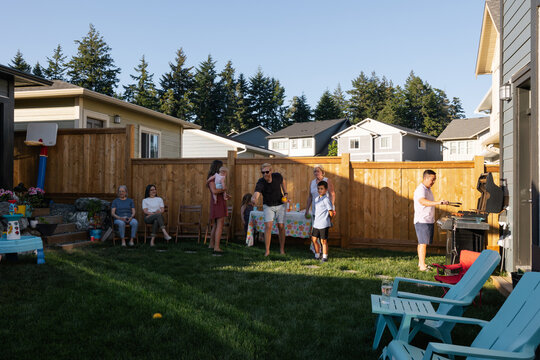 A group of family and friends enjoying a summer backyard barbequ