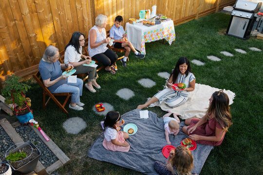 A group of family and friends enjoying a summer backyard barbequ