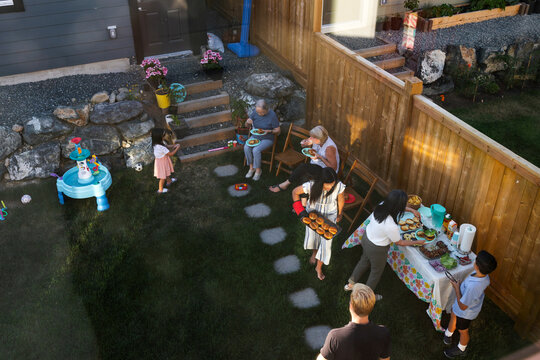 A group of family and friends enjoying a summer backyard barbequ