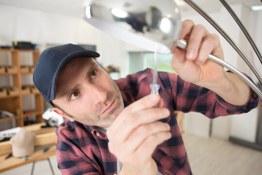 Electrician Installing Light Bulb On The Ceiling