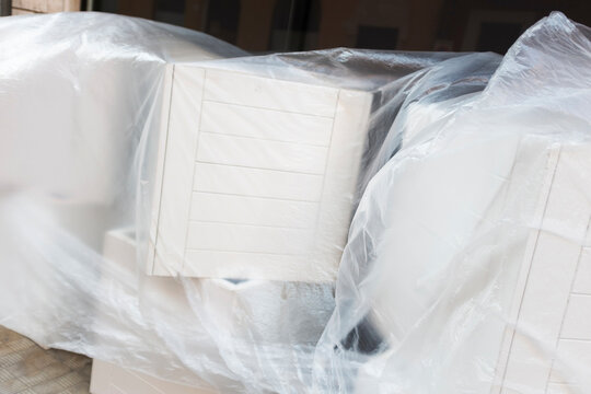 White geometrical boxes wrapped in clear plastic