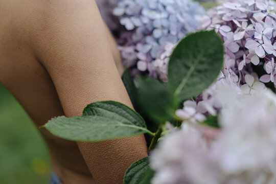 Naked woman with bouquet of hydrangea 
