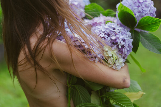 Naked woman with bouquet hydrangea flowers