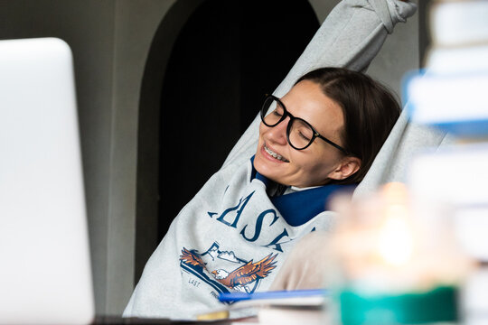 Happy college student stretches after studying online