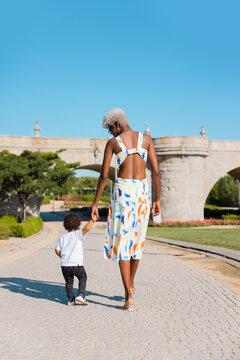 Black woman walking on street with a baby