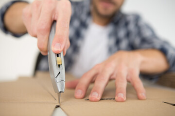 man cutting wood with knife