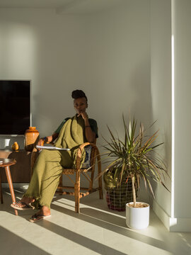Female sitting on chair in living room with sunlight