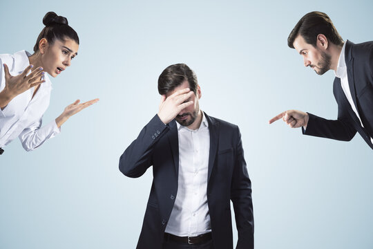 Young businessman dealing with bullying and stress at workplace on white background. Attractive european businessmen portrait.