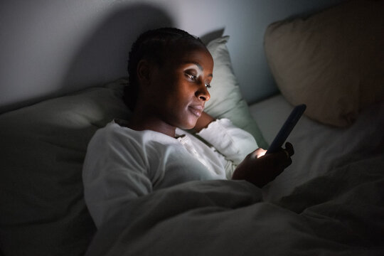 Black woman using app on smartphone at night