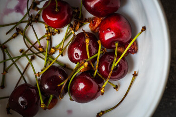 Freshly harvested ripe cherries on the dark rustic background. Selective focus. Shot from above.