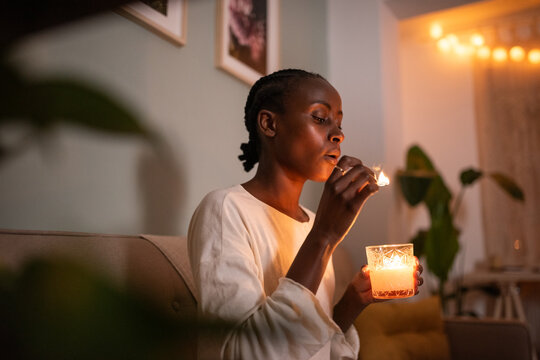 Black woman blowing out burning match